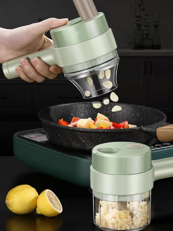 A hand uses a mint green electric garlic press over a frying pan with chopped garlic, onions, and red peppers on a portable stove. A second view shows the mint green electric garlic press container filled with chopped garlic in the foreground, with lemons on the table next to it.